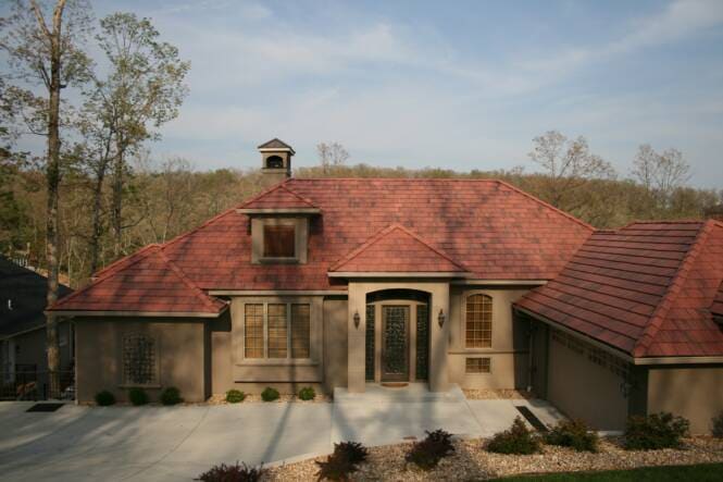 Home under a red tile roof with an arched stucco entry and rooftop cupola