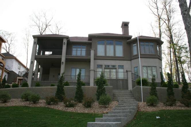 Multi-story lake home with stacked decks over a stucco exterior
