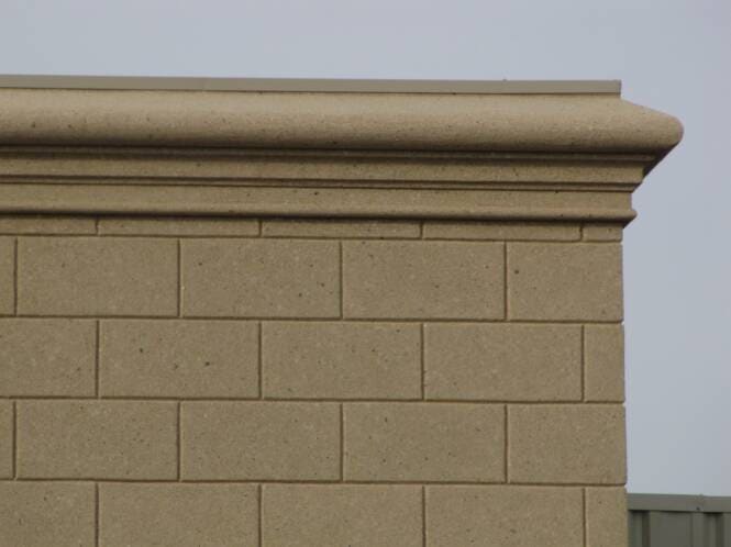 Parapet cap and cornice above ashlar-scored stucco