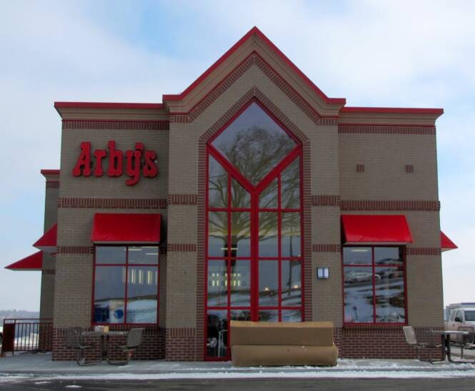 Restaurant exterior with stucco walls and a peaked glass entry