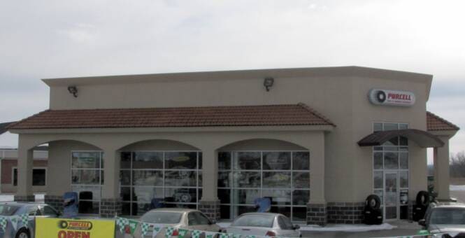 Automotive service building with arched window openings in stucco