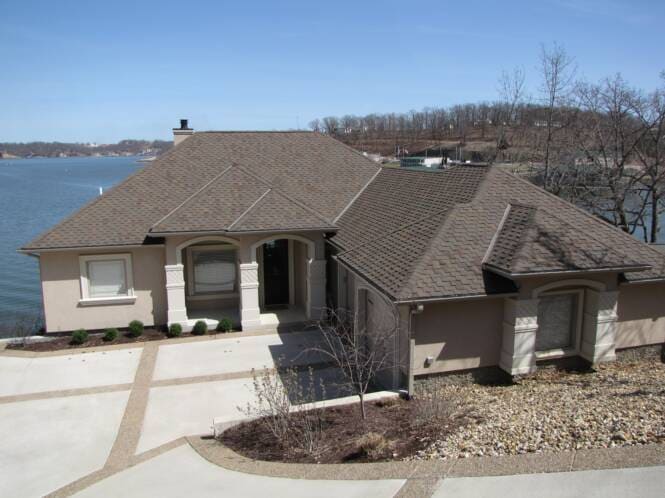 Lakefront home with stucco walls and a stone entry surround