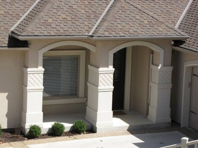 Arched entry openings framed by patterned stucco pilasters