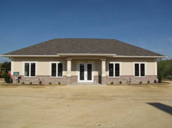 Single-story commercial building in stucco over a stone base