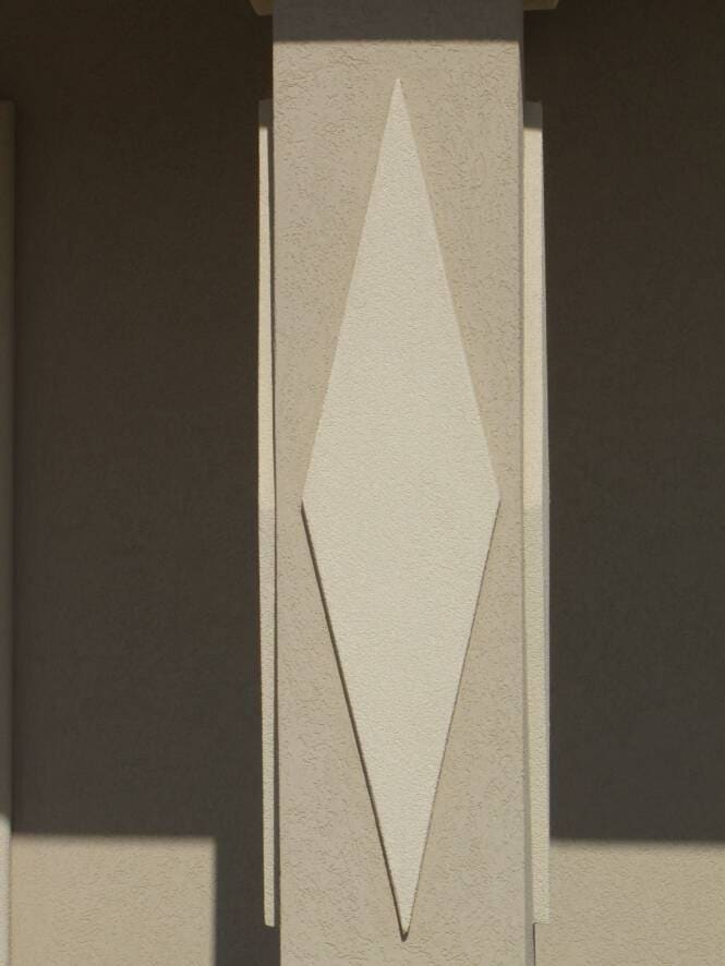 Two-tone diamond inlay set into a stucco pilaster
