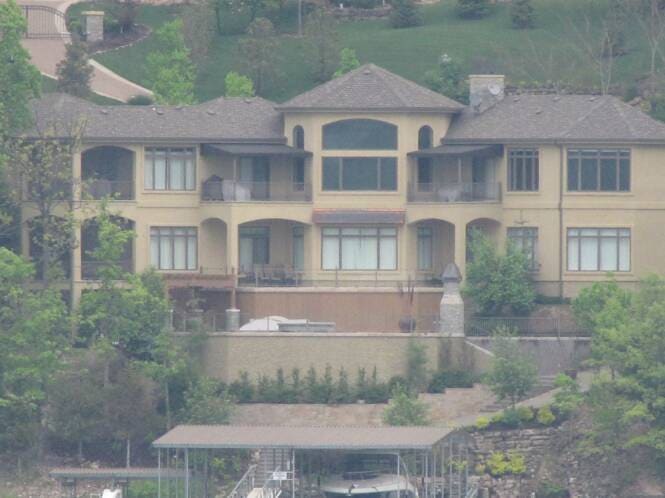 Hillside lake home with stepped stucco elevations and balconies