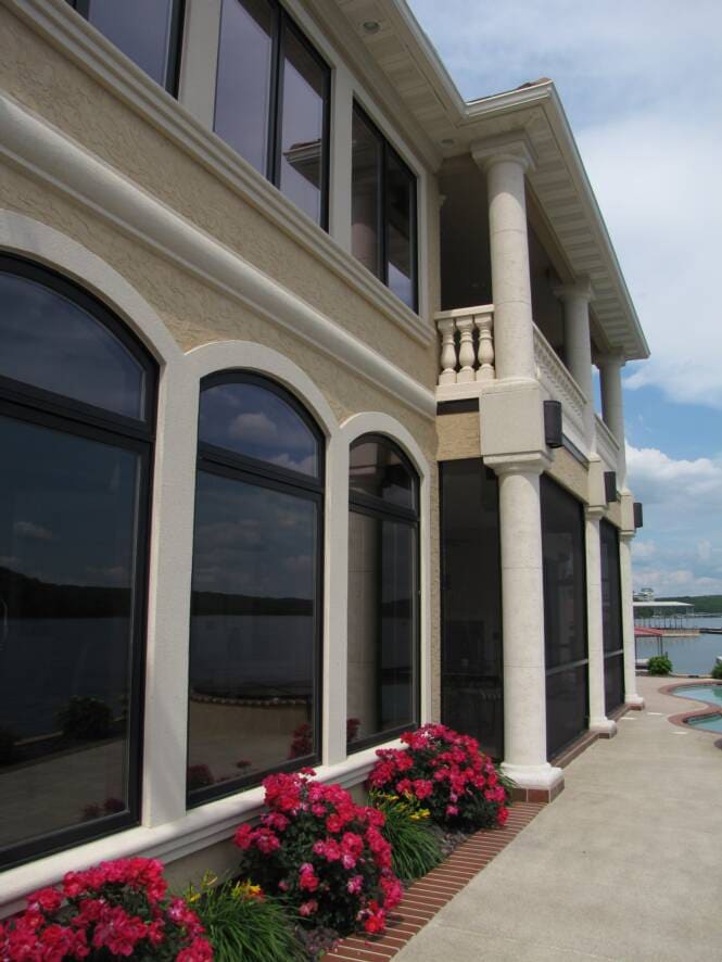Lakefront residence with stucco columns and arched window openings