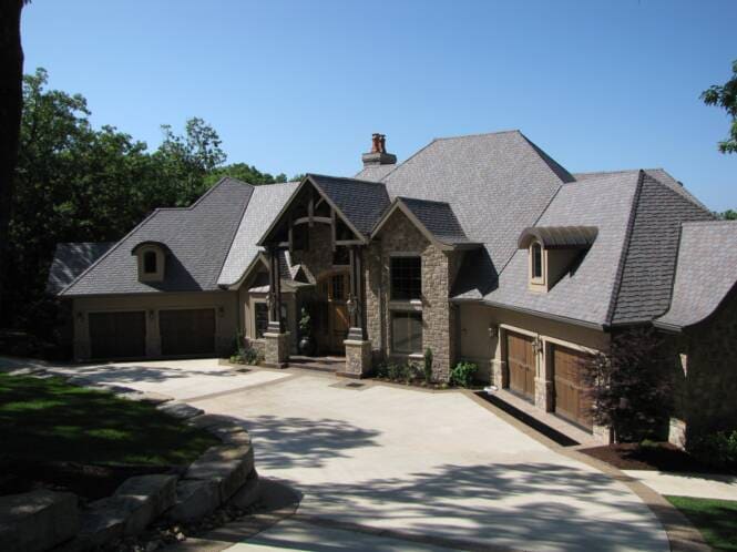 Large residence combining stone and stucco under steep gables