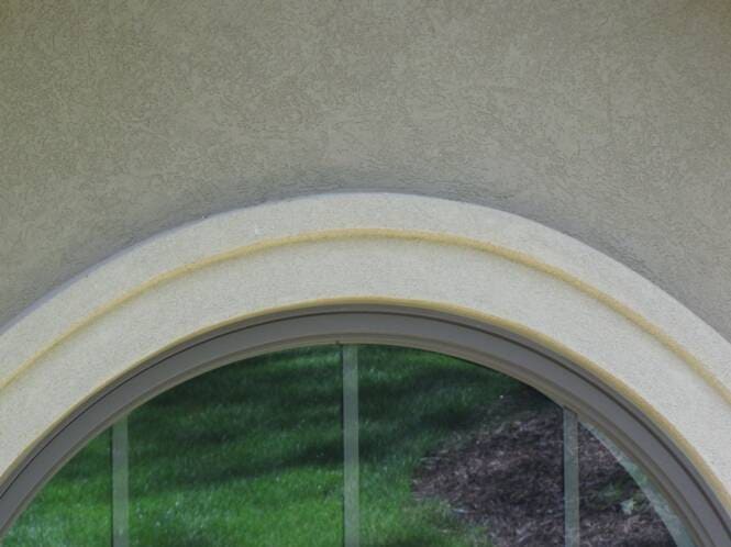 Half-round window head trimmed in stucco