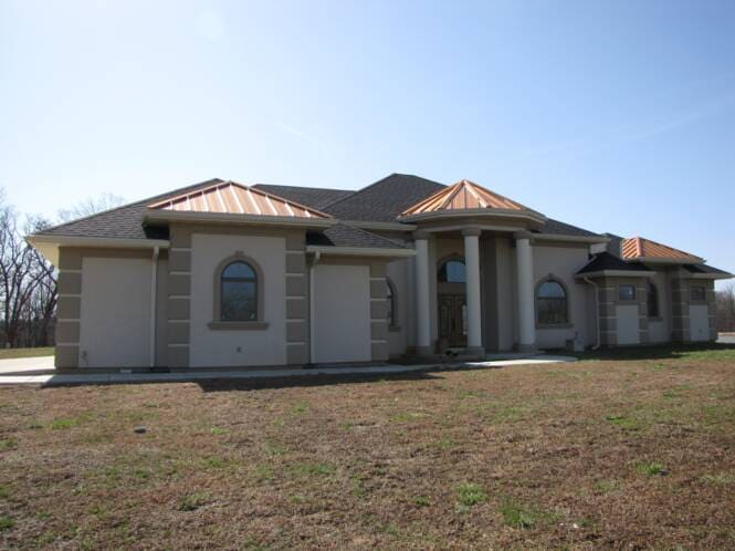 Single-story home with stucco columns and copper roof accents