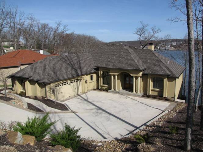 Long hillside residence in stucco with a series of arched openings