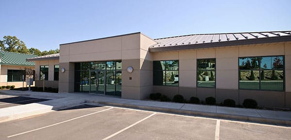 Single-story commercial building with a stucco facade and full-height glazing